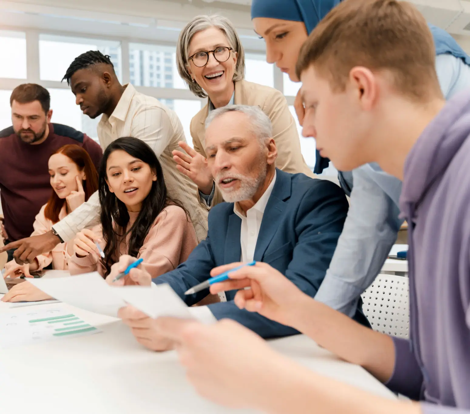 Diverse group collaborating on a project with enthusiasm and focus.